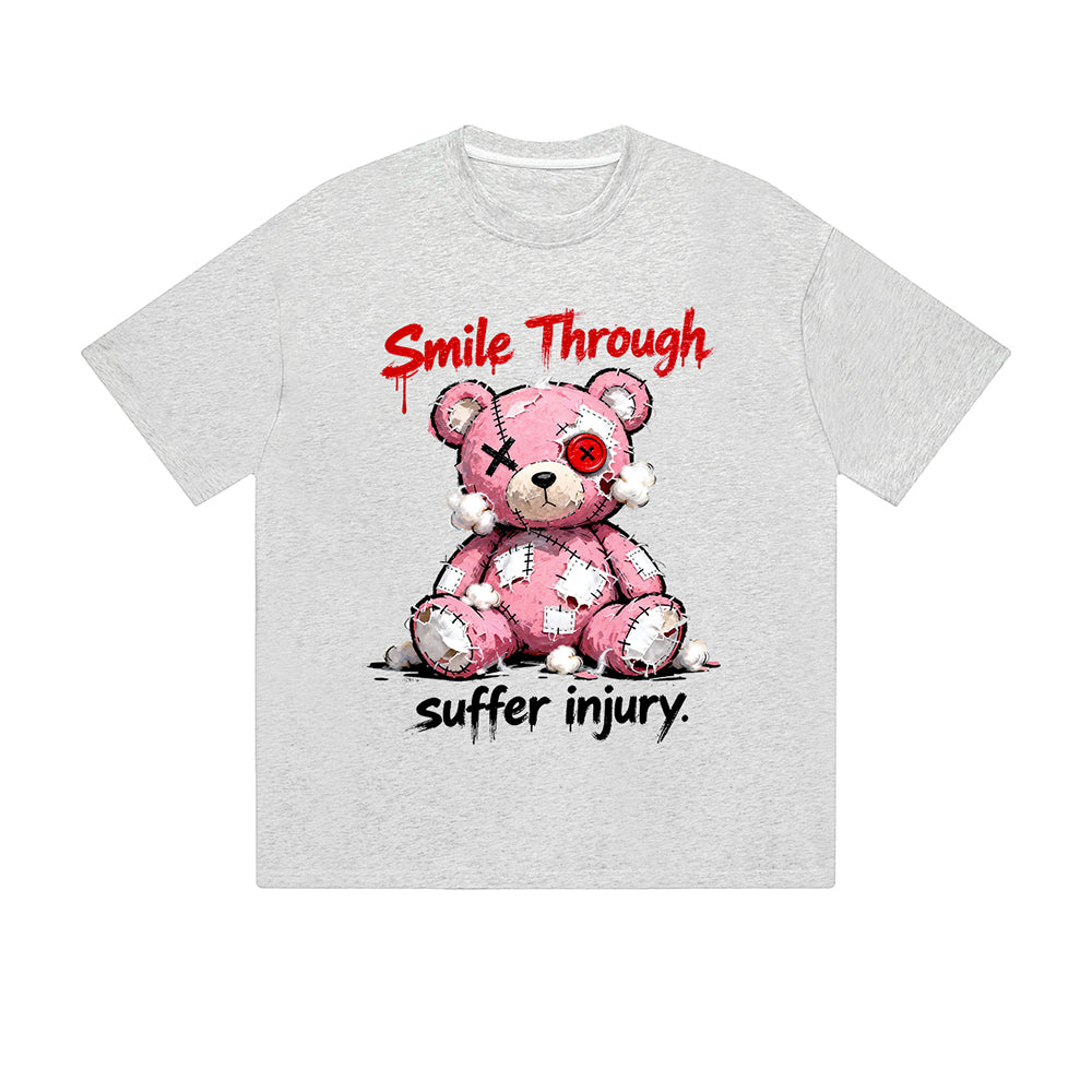 T-shirt uni « Sourire malgré la blessure » ​​ours rose brodé, texte motivant, imprimé graphique, style streetwear décontracté, pour tous les jours. Ressentez la vie.